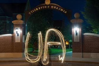 AU spelled out with sparkler in front of arch